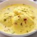 Ras Malai, a quintessential Indian dessert, is a spongy and creamy delight prepared with fresh cheese called 'chhena'. The chhena is cooked in sugar syrup and soaked in a cardamom-flavored sweet milk syrup known as 'rabdi', adorned with chopped almonds and pistachios.