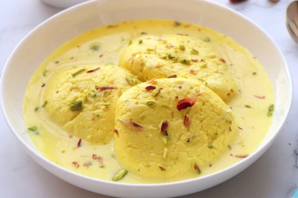 Ras Malai, a quintessential Indian dessert, is a spongy and creamy delight prepared with fresh cheese called 'chhena'. The chhena is cooked in sugar syrup and soaked in a cardamom-flavored sweet milk syrup known as 'rabdi', adorned with chopped almonds and pistachios.